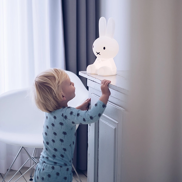 dítě se dívá na dětskou lampu Miffy